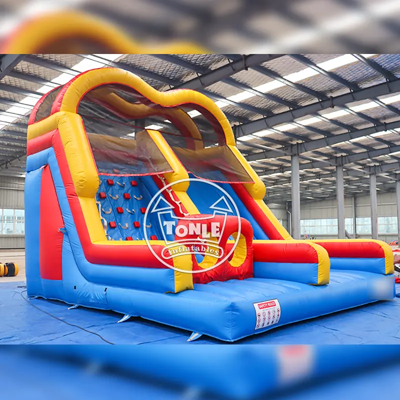 Green and yellow inflatable climbing wall and slide combo with mesh safety netting