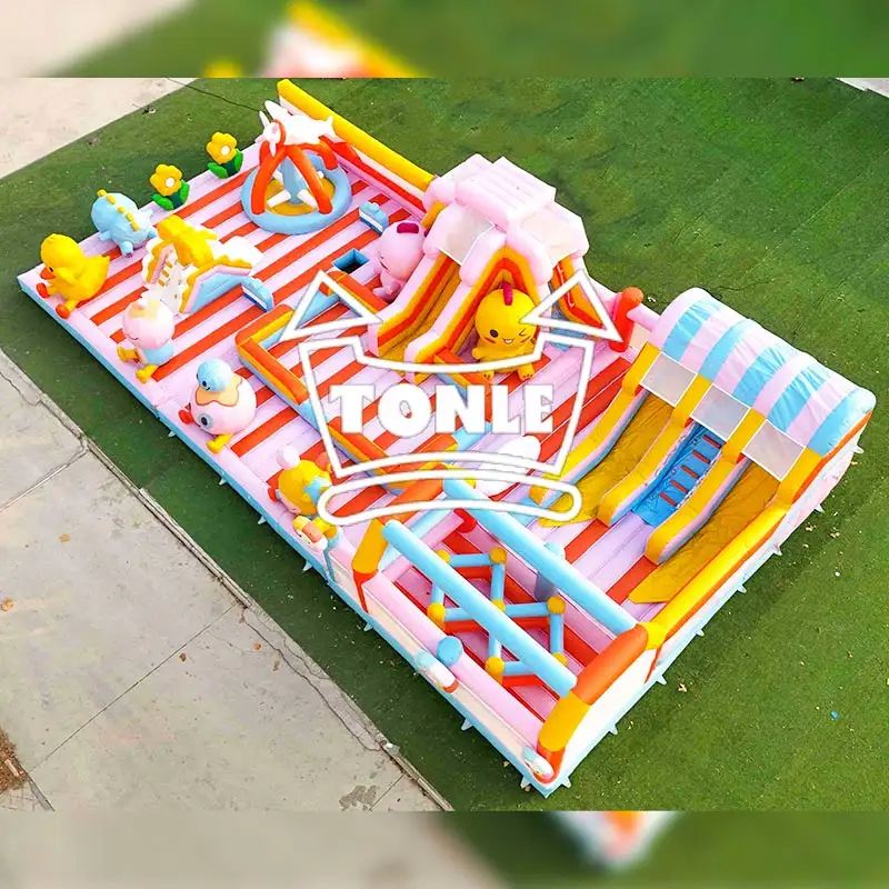 Aerial view of 25x15m yellow duck inflatable park with pink slides and striped floor