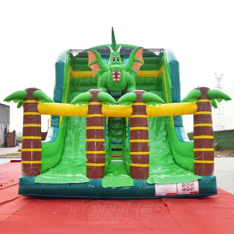 Front view of green inflatable dinosaur slide with 3D dragon head and palm tree columns