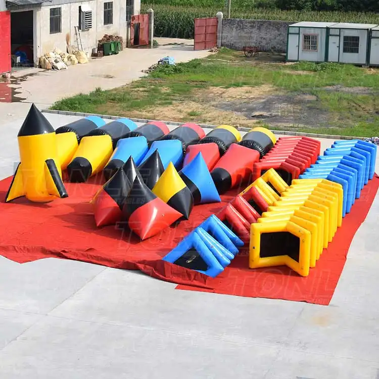 Custom inflatable paintball bunker set with red blue yellow and black obstacles on red tarp