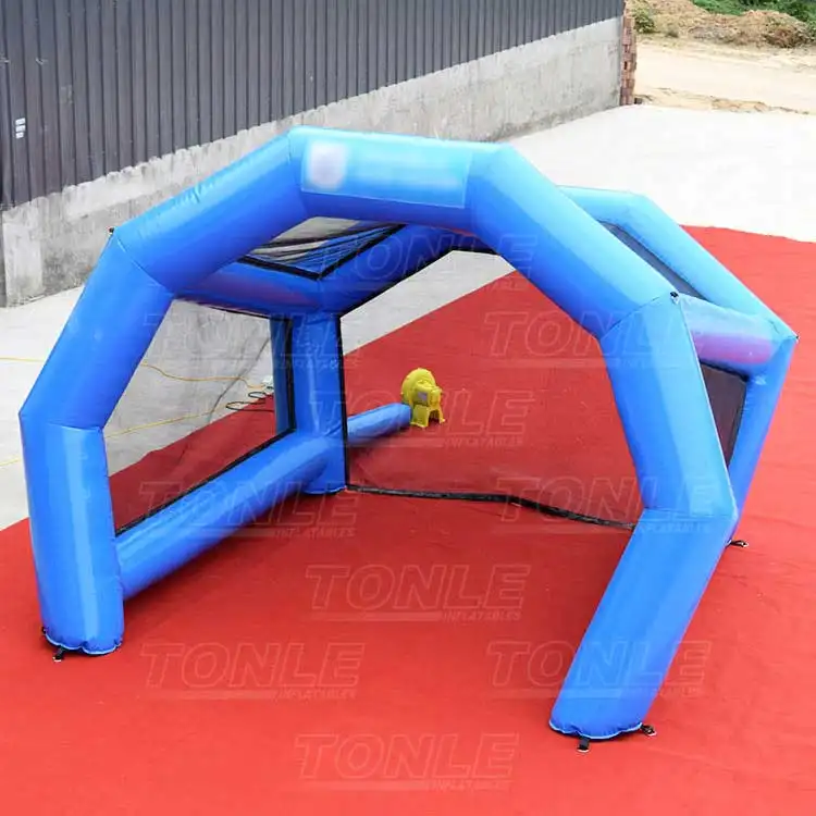 Blue geodesic inflatable sports cage with black mesh netting on red carpet