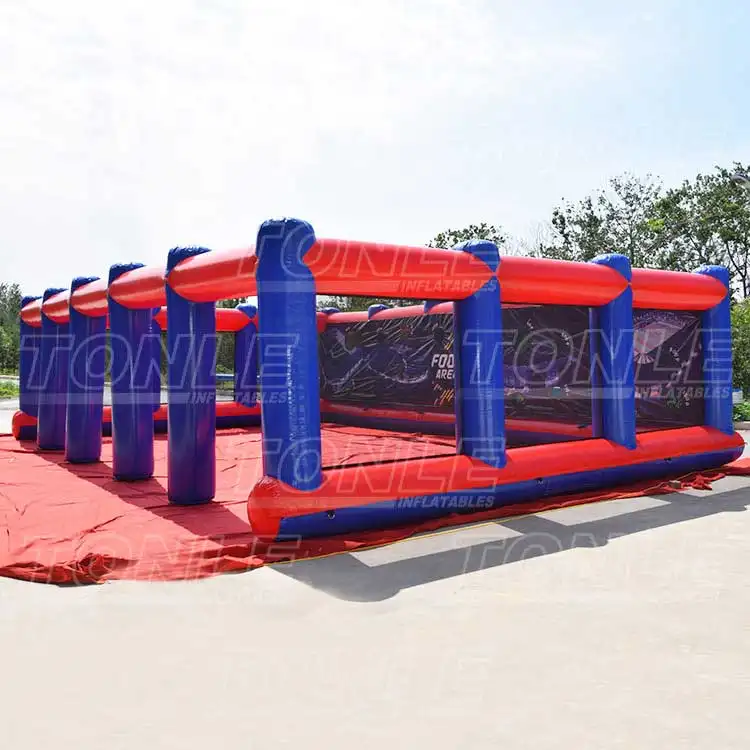 Red and blue 12x8m inflatable football shooter game with mesh walls on concrete
