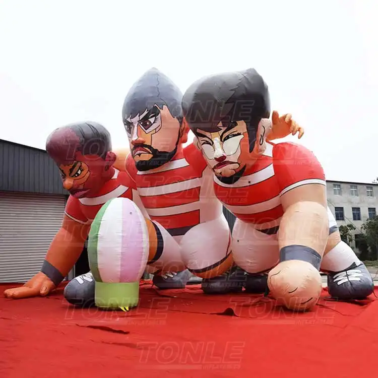 Giant 9m inflatable rugby player replica showing three athletes in red and white jerseys in a scrum