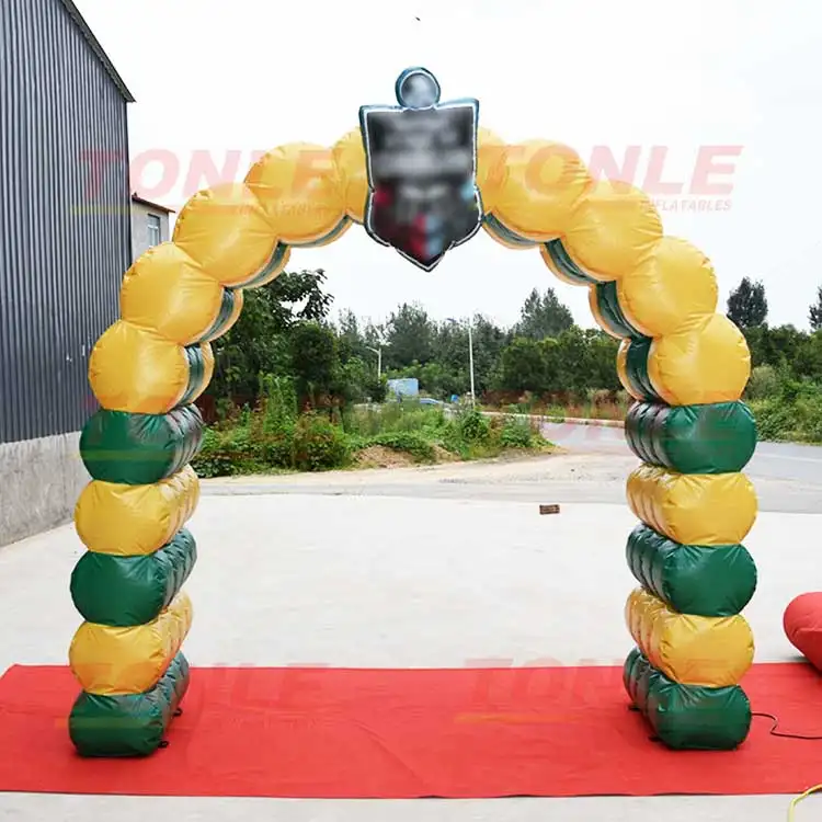 Yellow and green segmented inflatable archway with central shield logo on red carpet