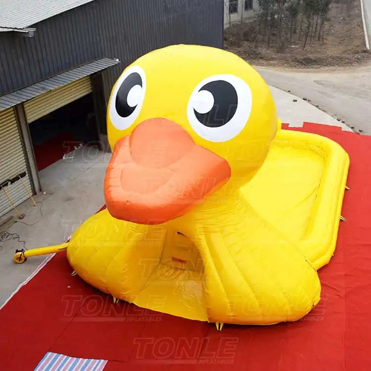 Giant yellow duck inflatable water pool with orange beak on red ground tarp