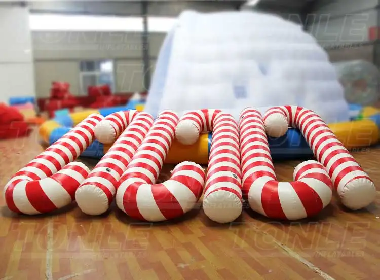 Row of red and white striped 3m inflatable candy canes on wooden floor