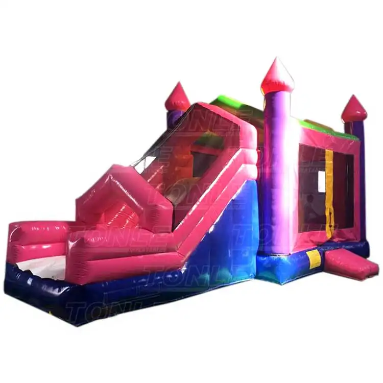 Pink and purple inflatable bounce house with slide and castle turrets measuring 8.3m