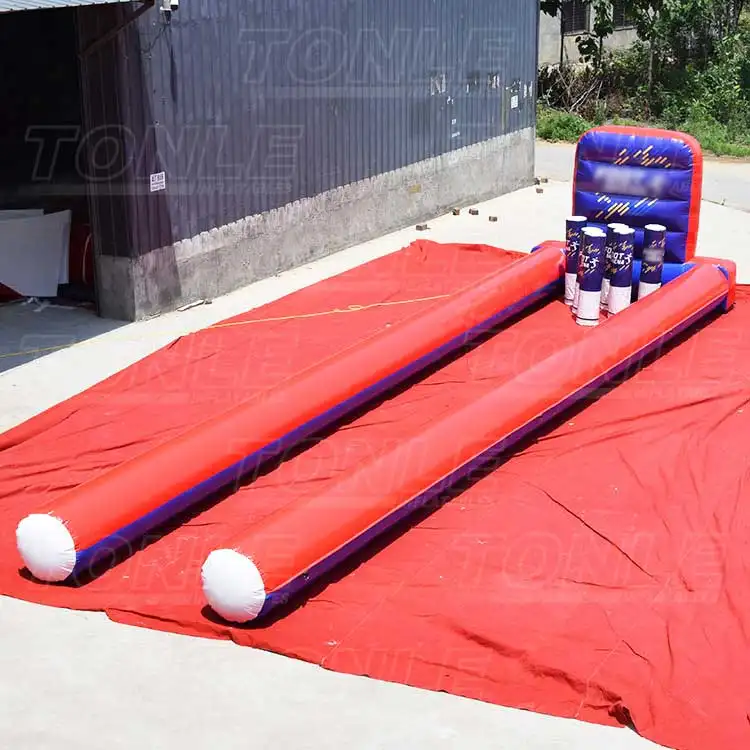 Red and blue 12x3m inflatable soccer bowling game with dual lanes and giant pins