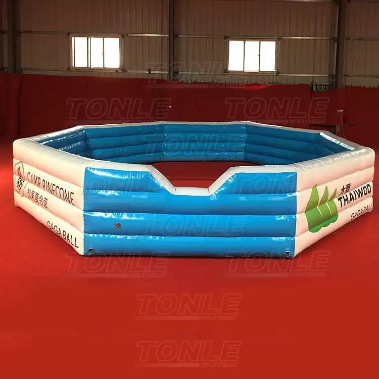 Blue and white octagonal inflatable Gaga Ball pit with Camp Pinecone branding on red floor