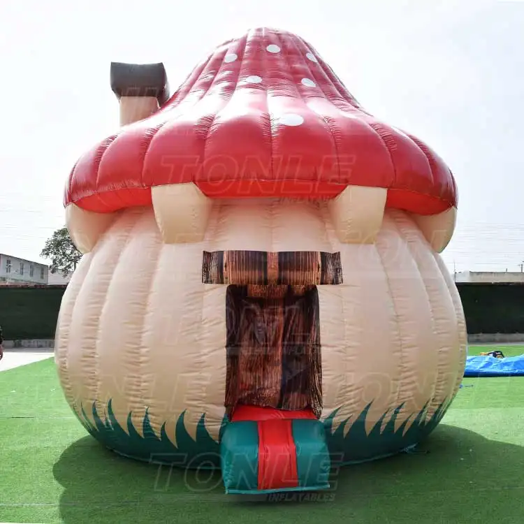Front view of red and beige Mushroom house bouncy castle 5x5m on green turf