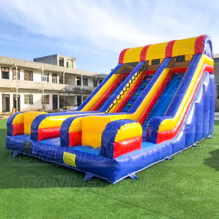 Blue yellow and red dual lane inflatable dry slide on green turf
