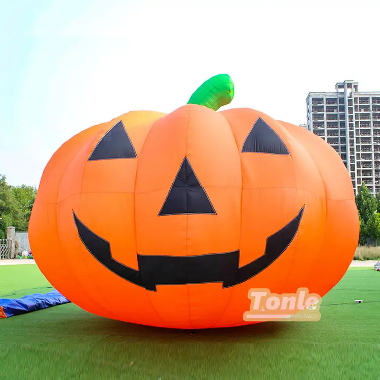 6m inflatable pumpkin with orange body and black face on grass