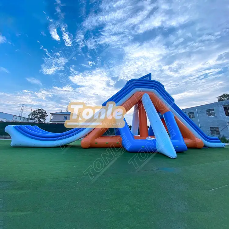 Blue and white striped inflatable water park slide with orange supports on grass