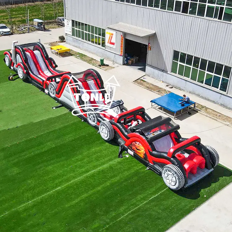 Aerial view of a 28m red and black monster truck themed inflatable obstacle course on green turf