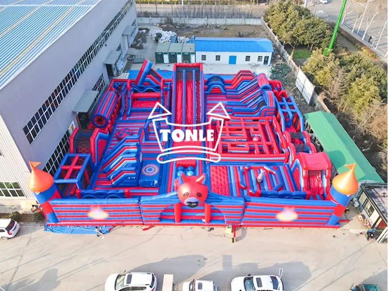 Aerial view of 35m x 35m red and blue inflatable puppy theme game park with obstacle course