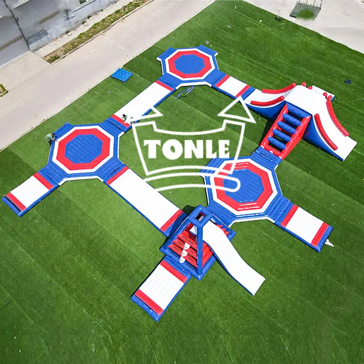 Aerial view of custom blue red and white floating water park with hexagonal platforms on grass