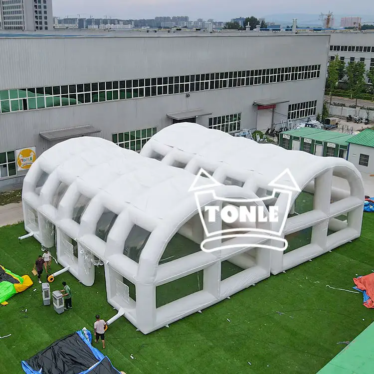 Aerial view of a large white 16x10m dual-arch inflatable tent on green turf