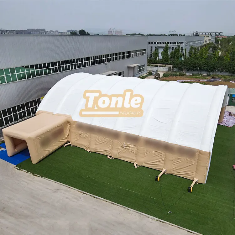 Aerial view of a large white and beige custom inflatable tent measuring 50x20x8m on green turf