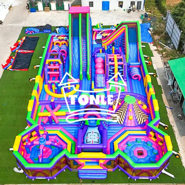 Aerial view of 28x17m colorful inflatable fun park with purple and green obstacles