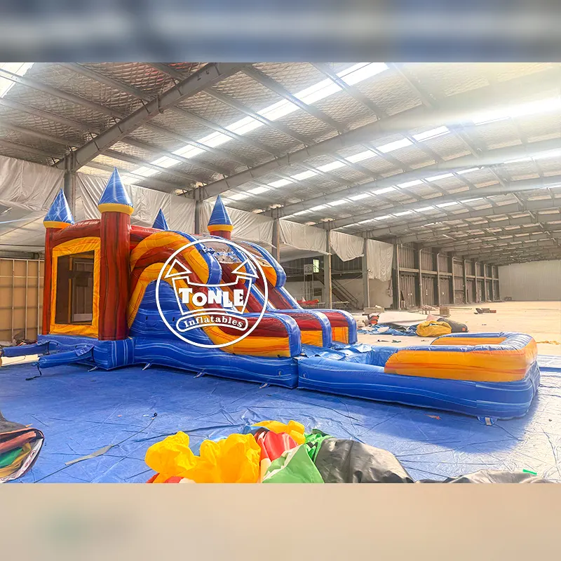 Blue and red castle wet bounce house combo with dual slides and splash pool in warehouse