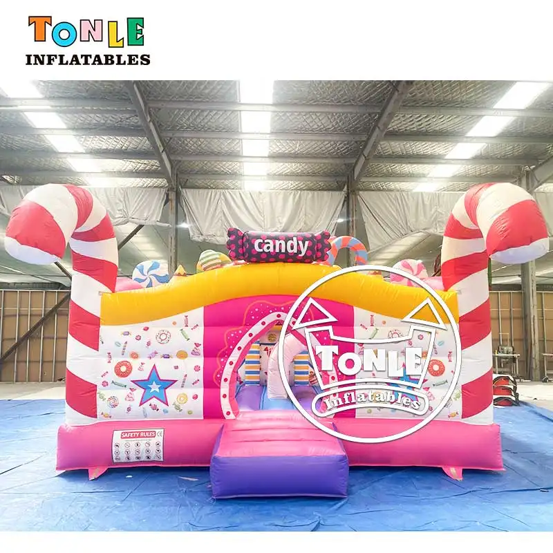 Front view of pink and white candy themed inflatable playground with red candy cane pillars