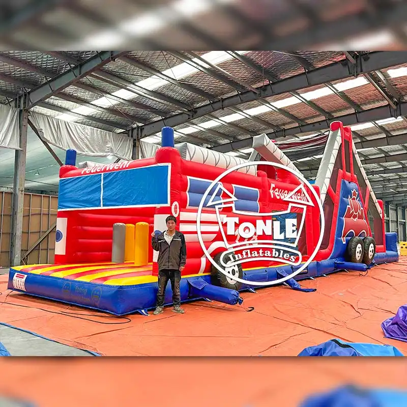 60ft Fire Department Linear Obstacle Course showing red and blue fire truck design with climbing wall and slide exit